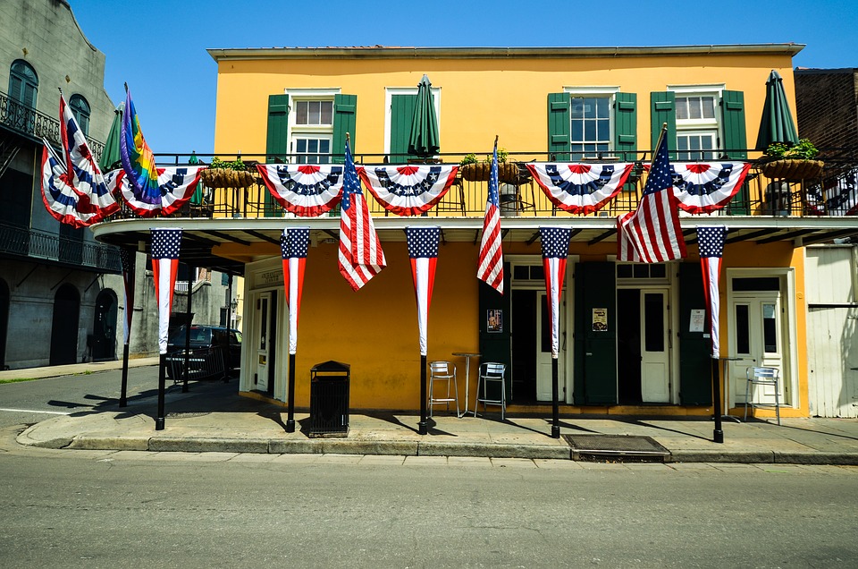 A mustard yellow saloon bedecked in red, white, and blue flags in New Orleans.
