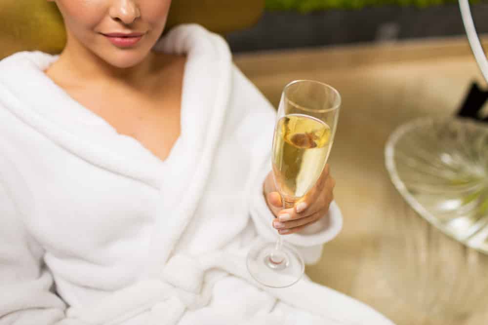 person-in-robe-holding-champagne-glass