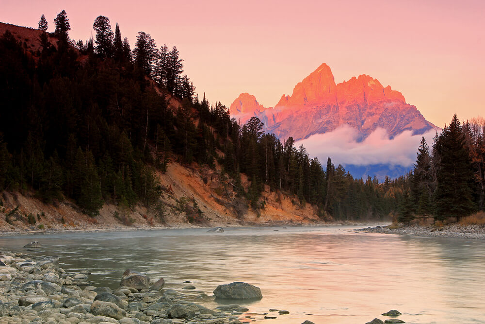 A sunrise staining the Grant Teton's in light pink.